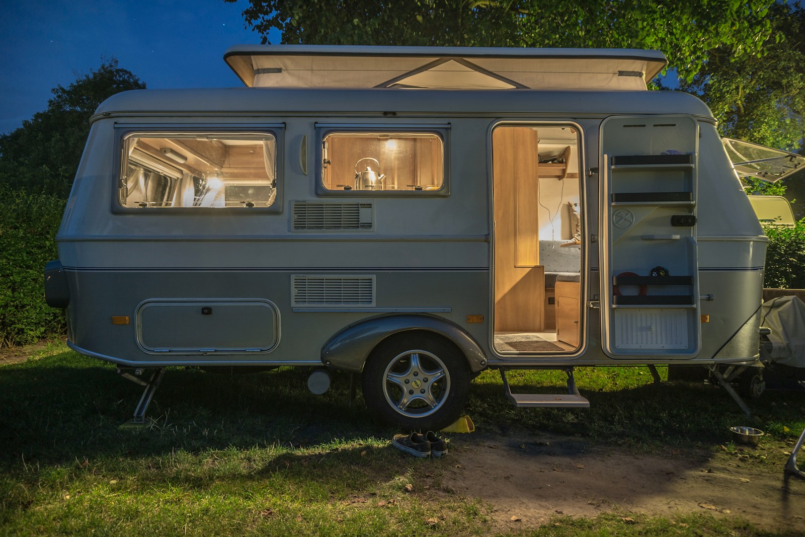 white and brown camper trailer beside tree